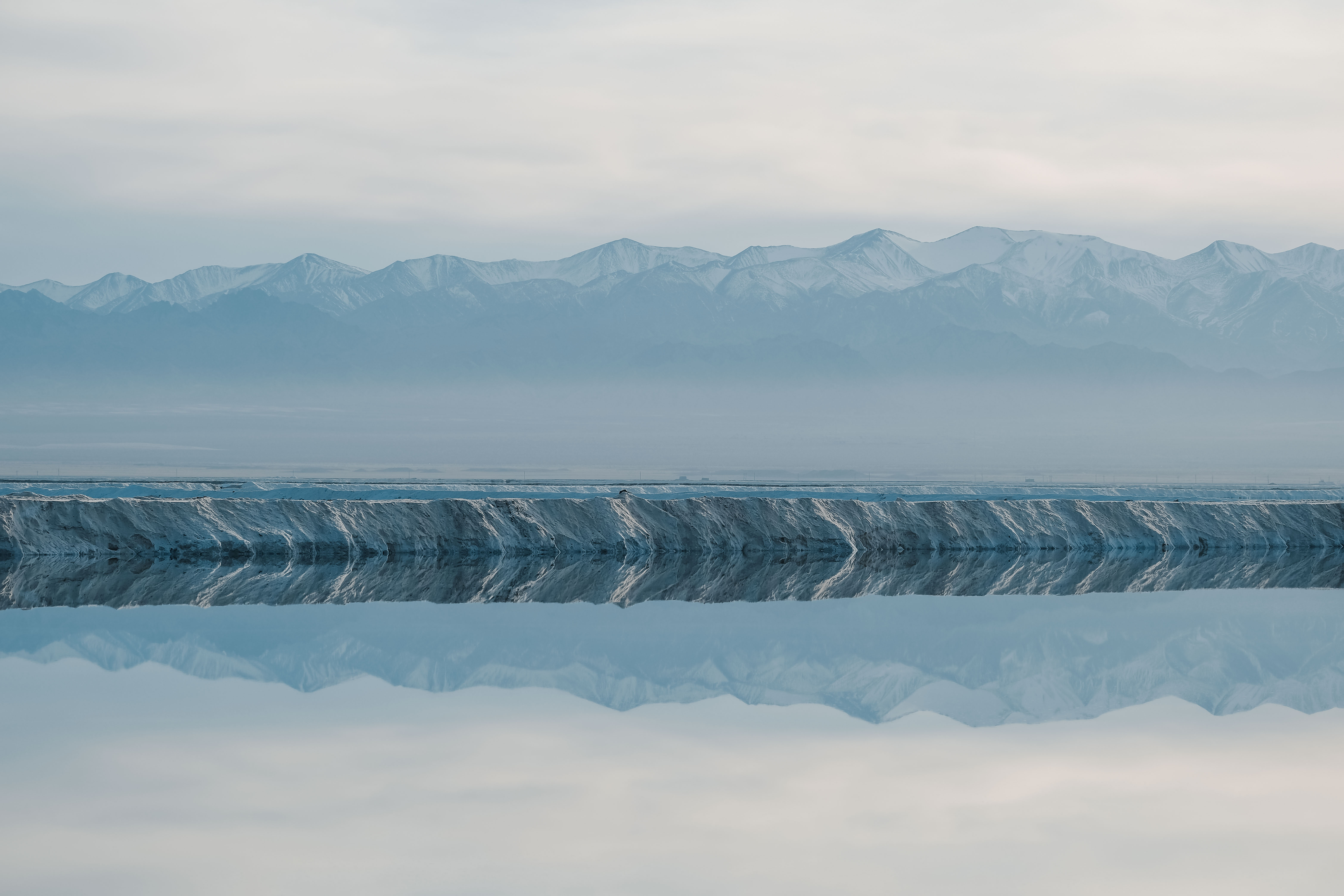 A salt lake reflecting a distant mountain range