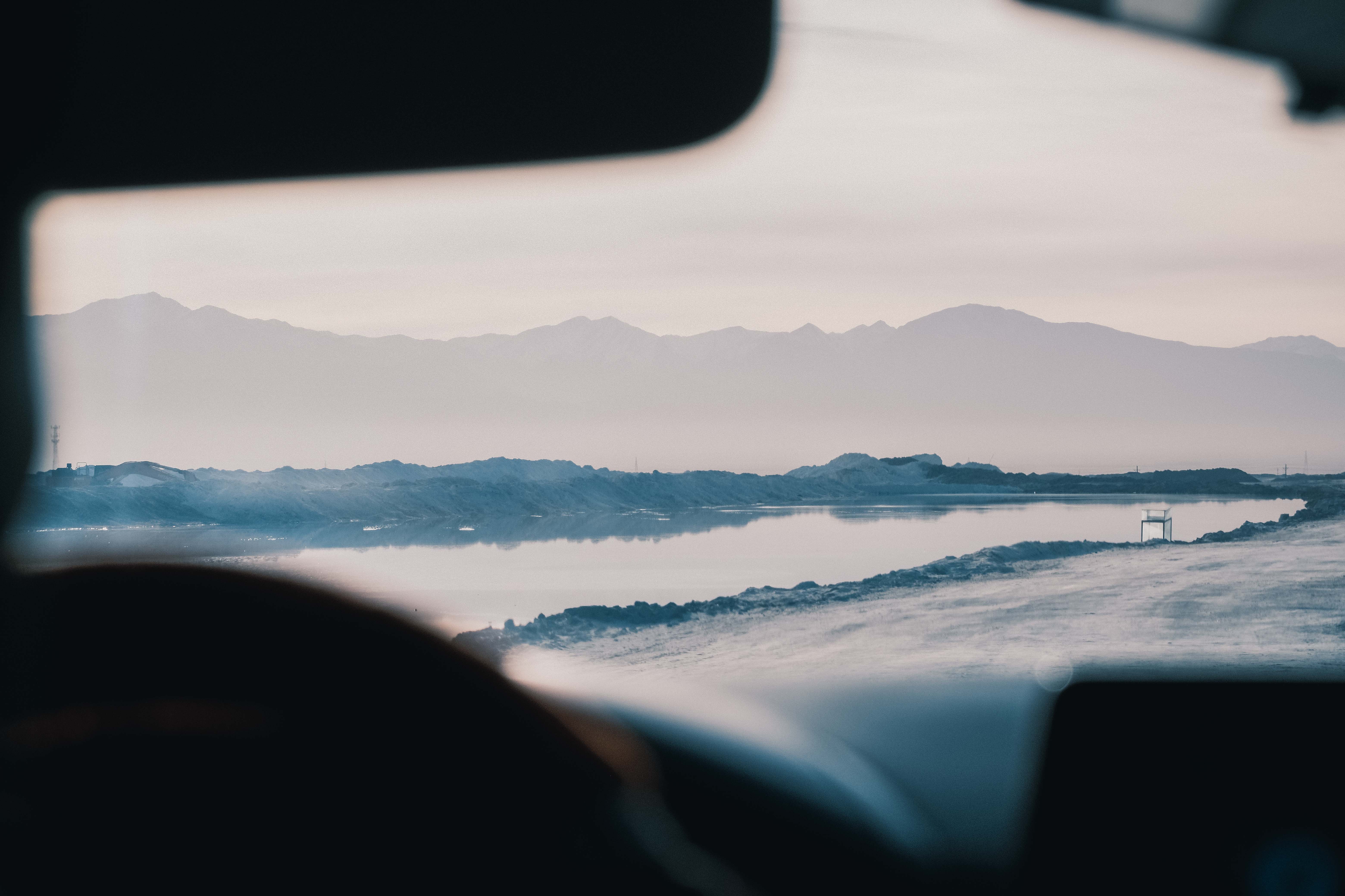 A salt lake viewed through the window of a vehicle