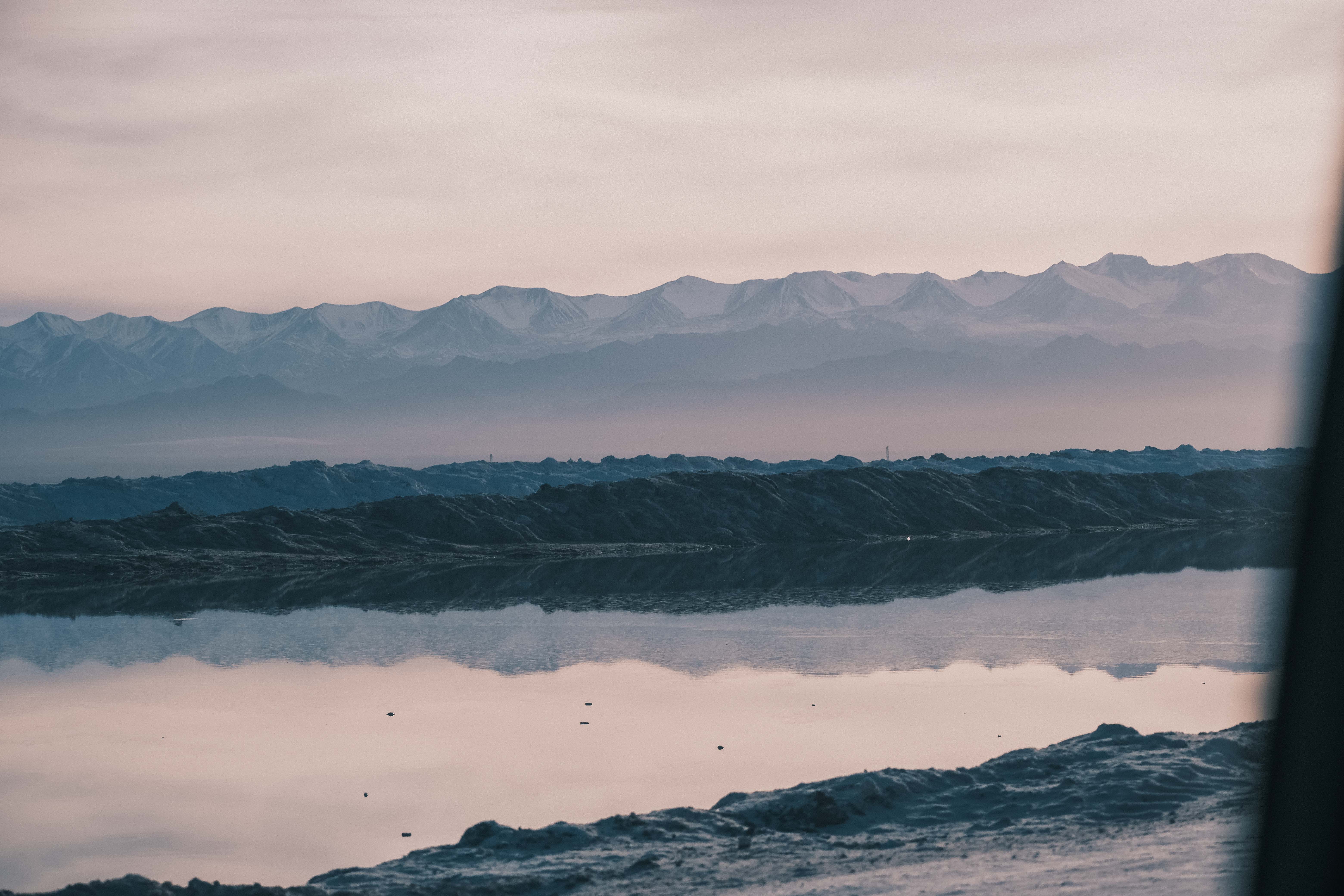 Still brine reflecting salt deposits and distant mountains