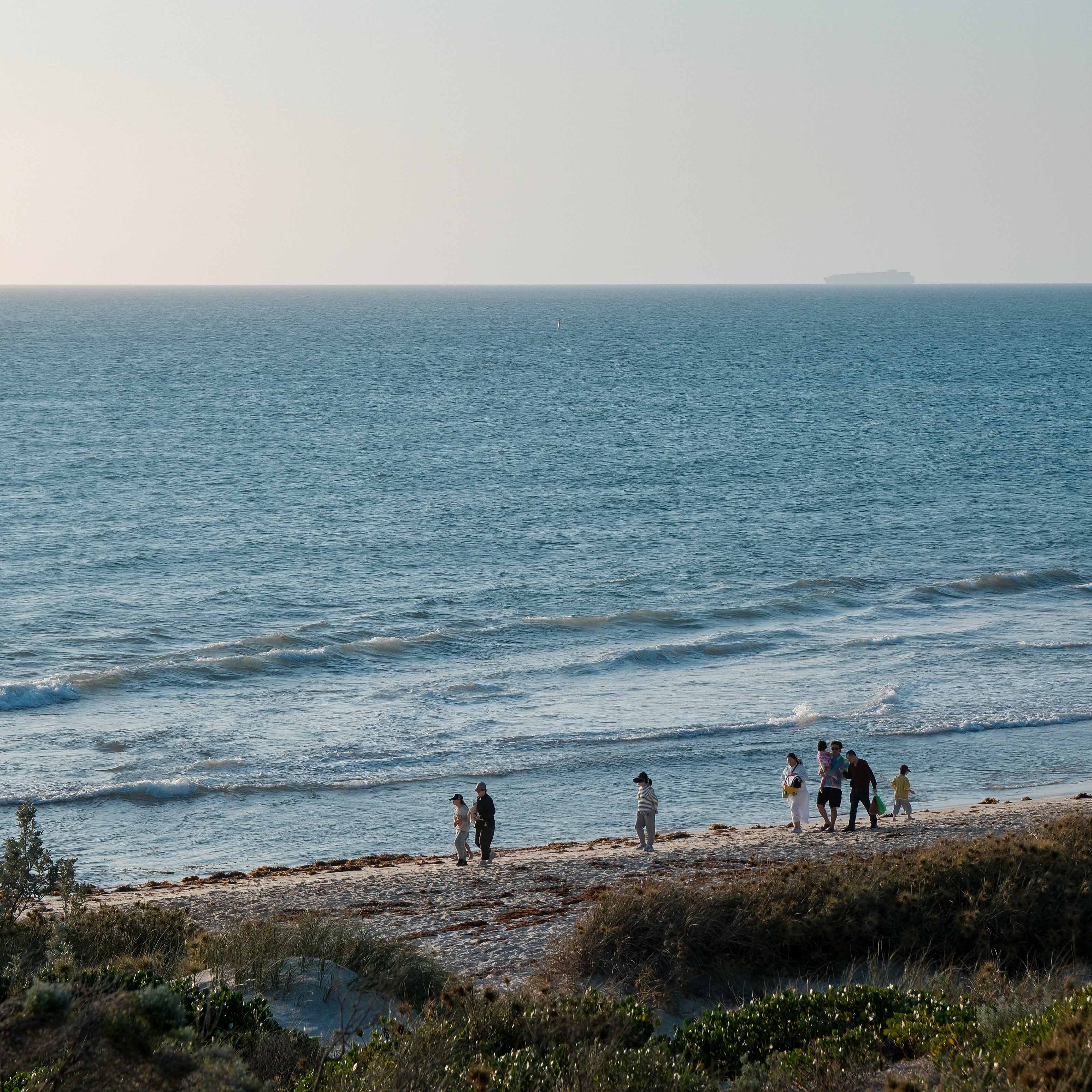People wandering along the shoreline