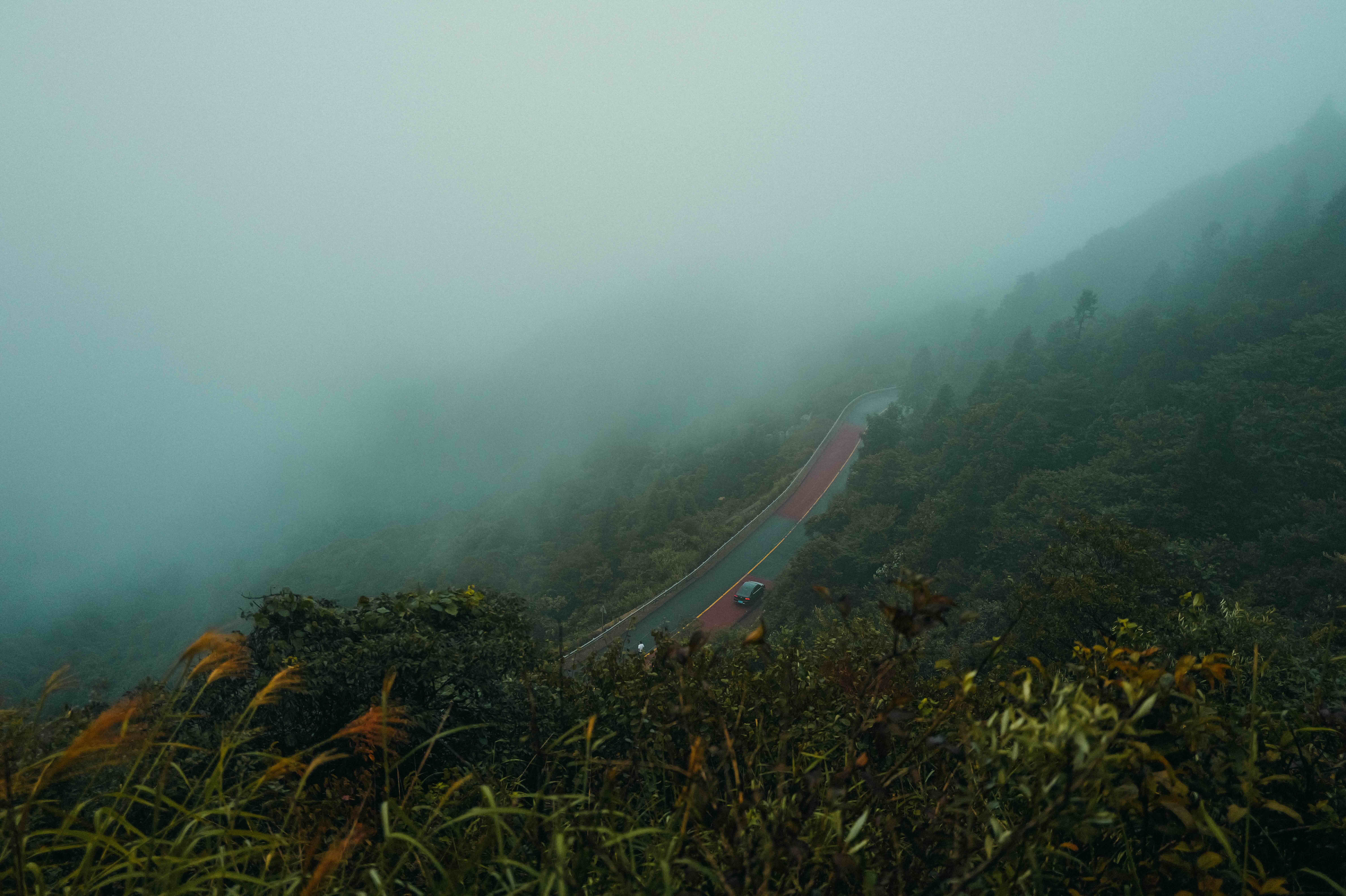 A mountain valley and road covered in cloud